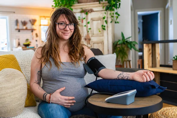 Беременная женщина использует измеритель артериального давления — стоковое фото