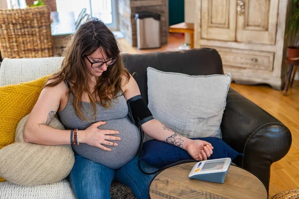 Mujer embarazada utiliza medidor de presión arterial — Foto de Stock