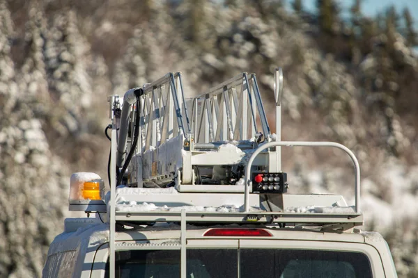 Ladder atop a utility vehicle in winter
