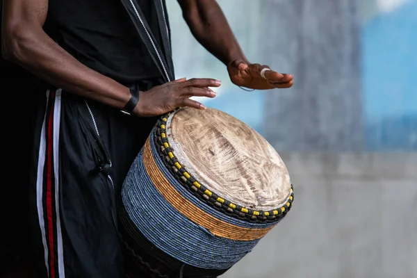 Middensectie van de Afrikaanse man die djembe drums speelt — Stockfoto