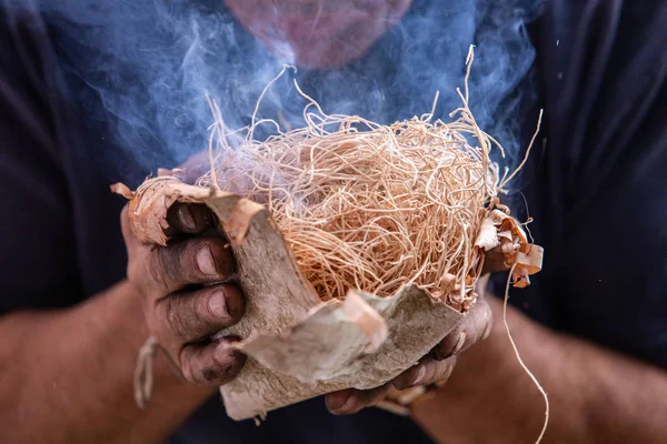 Man holding burning fire straw