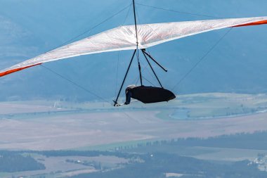 Vadi, tarlalar ve dağlar üzerinde planörle uçmak