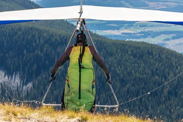 Extremal man with hang-glider preparing to fly