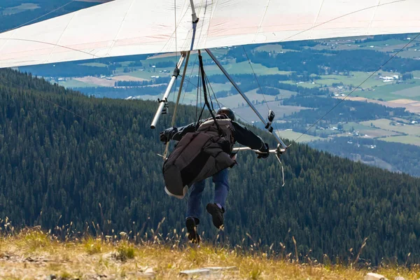 Extremal man with hang-glider preparing to fly