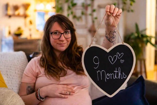Pregnant woman and nine month heart sign — Stock Photo, Image