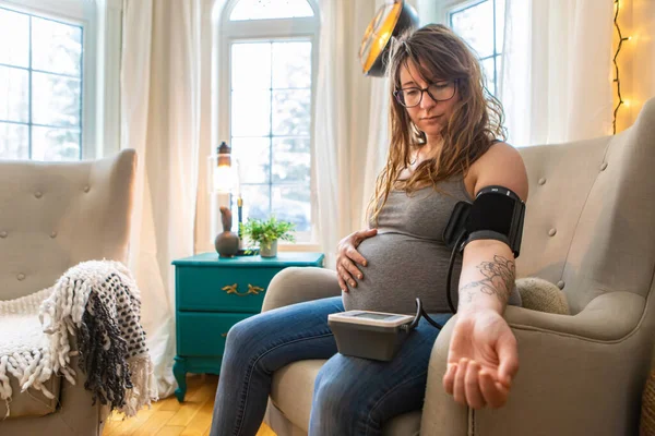 Mujer embarazada utiliza medidor de presión arterial — Foto de Stock