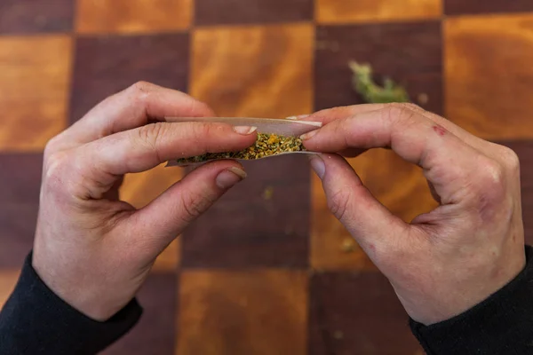 Рука раскатывает марихуану с нуля — стоковое фото