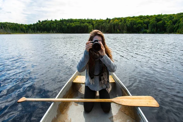 Жінка в каное, клацаючи фотографії з DSLR — стокове фото