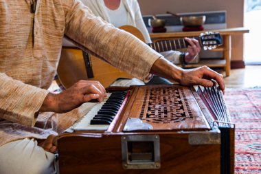 Man and woman hands play harmonium and guitar clipart