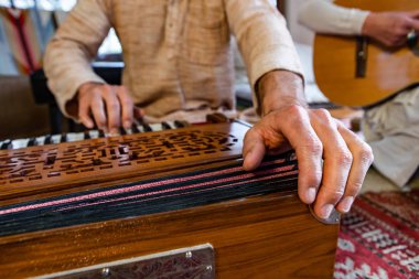 Male playing keys on harmonium