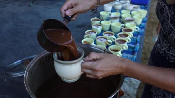 Vrouw hand gieten chocolade in meerdere kopjes — Stockvideo