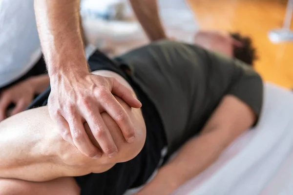 Спортивний фізіотерапевт масажує м'язистого сильного чоловіка — стокове фото
