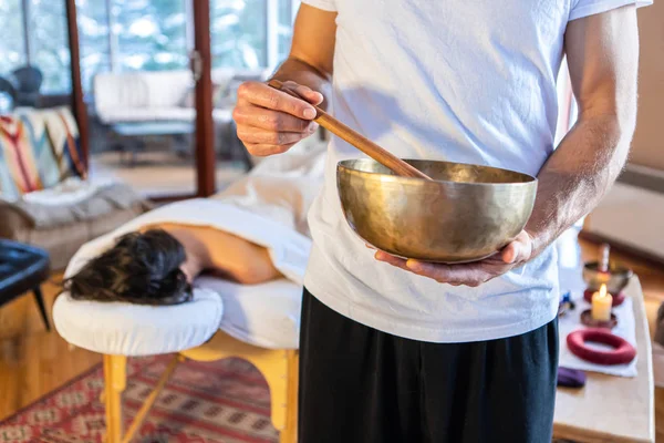 Woman getting a sound massage with singing bowls