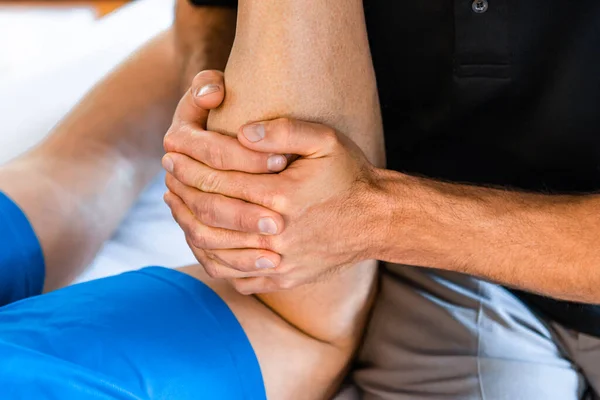 Fisioterapeuta deportivo masaje muscular fuerte hombre — Foto de Stock