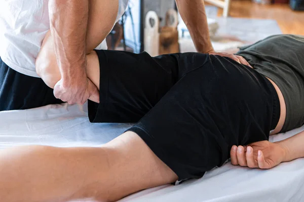 Fisioterapeuta deportivo masaje muscular fuerte hombre — Foto de Stock