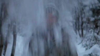 Gülen adam, karda tek başına eğlenmek için duruyor.