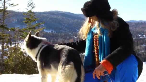 Felice vecchia donna accarezzando un cane husky alaskan — Video Stock