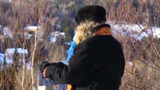 Yaşlı kadın kışın dışarıda duruyor. — Stok video
