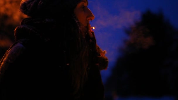 Girl smoking outside in winter, at night in the winter time — Stock Video