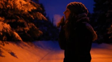 Kışın, kışın gece dışarıda sigara içen bir kız.