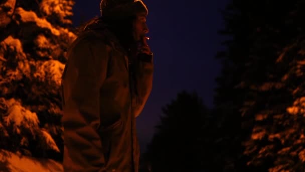 Man smoking outside in winter, at night in the winter time — Stock Video