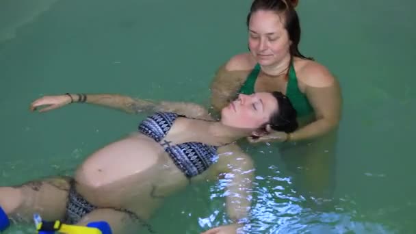 Schwangere mit Trainer im Schwimmbad — Stockvideo