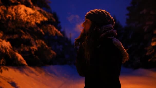 Chica fumando al aire libre en invierno, por la noche en invierno — Vídeo de stock