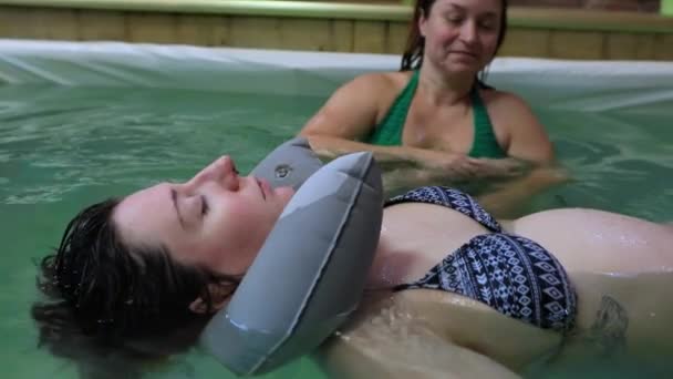 Ejercicio de mujer embarazada en piscina con entrenador — Vídeos de Stock