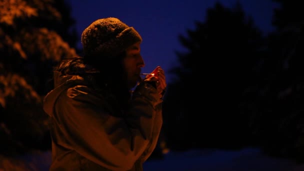 Man smoking outside in winter, at night in the winter time — Stock Video