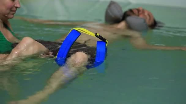 Терапевт дає чоловікові масаж коліна в басейні — стокове відео