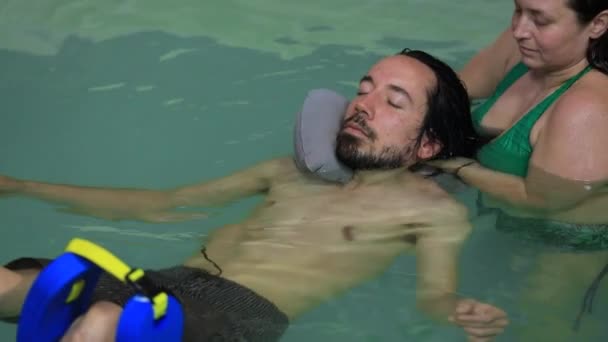 Terapeuta poniendo flotador cuello alrededor del cuello masculino — Vídeos de Stock