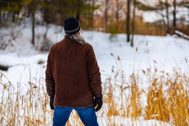 Young man standing and looking at the forest ahead