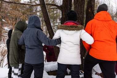 A conservation group standing around a tree