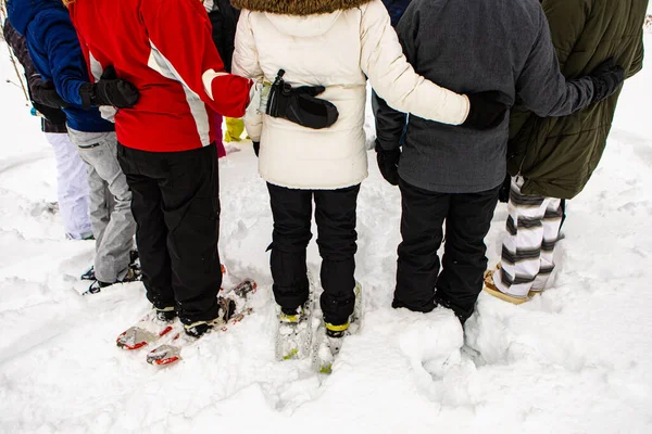 La gente se abraza y se detiene sobre la nieve — Foto de Stock