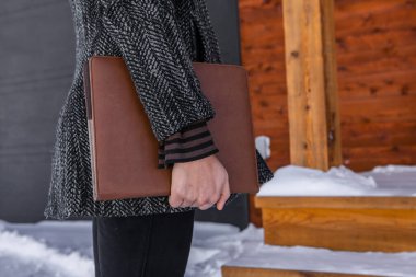 Elinde bir defter tutan tanınmayan bir kadın.