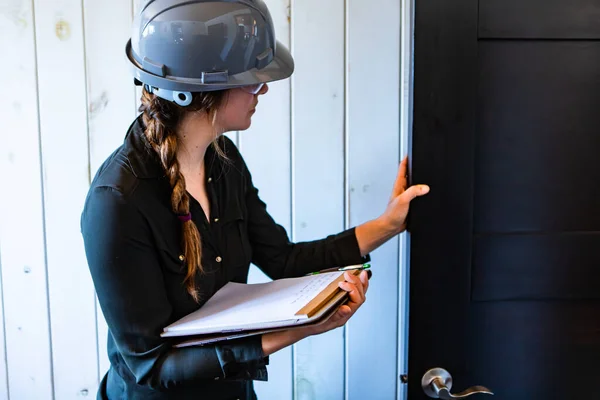 Female inspector reviews a room door — Stock Photo, Image