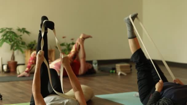 Woman using elastic band for leg exercise — Stockvideo