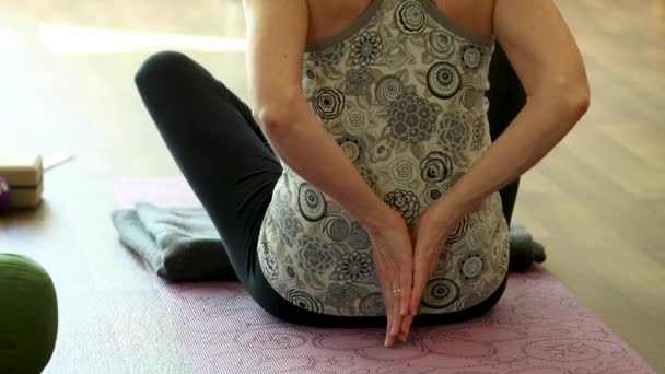 Mulher unindo as mãos na parte de trás enquanto faz ioga — Vídeo de Stock