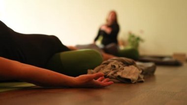 Group of people lying in shavasana exercising