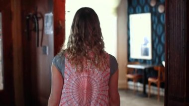 Kadın odaya giriyor ve erkekle tokalaşıyor.