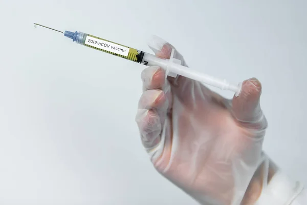 Covid vaccin gevulde naald gehanteerd door handschoen hand — Stockfoto