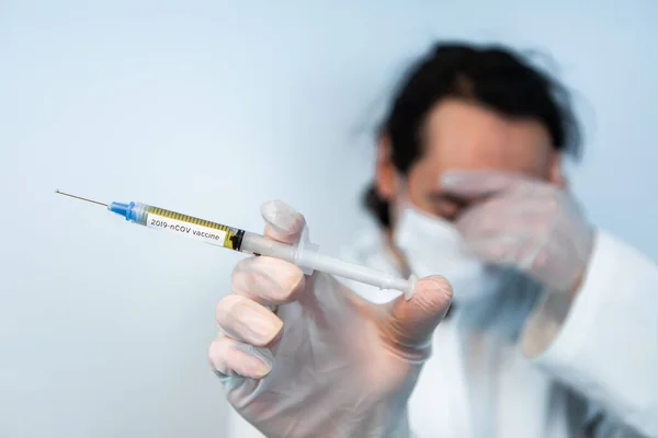 Droevige arts met spuit vol griepvaccin — Stockfoto