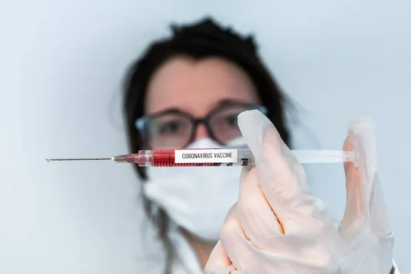 Lab tech houden coronavirus remedie in de naald — Stockfoto