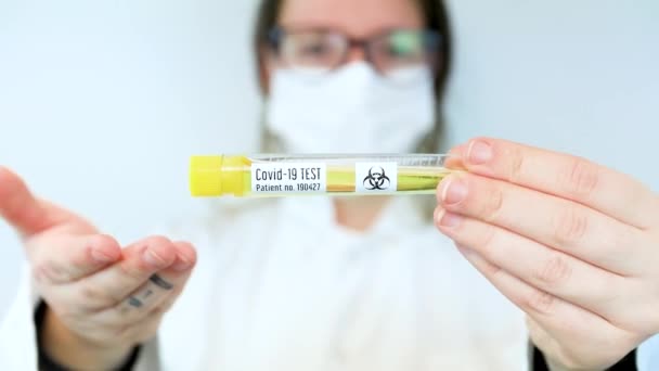 Lab tech presenta el vial de prueba covid 19 en laboratorio blanco — Vídeo de stock