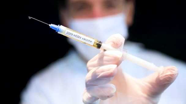 Médico segurando vacina vívida na seringa — Vídeo de Stock