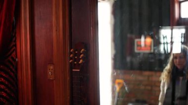 Neşeli kadın kapıyı açıyor ve bara giriyor.