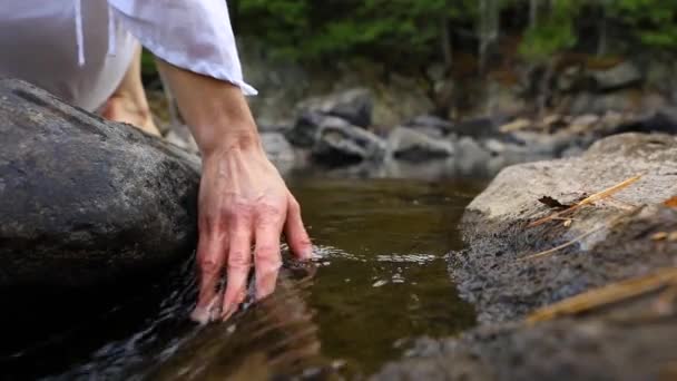 Hands touching flowing river water — Stock Video