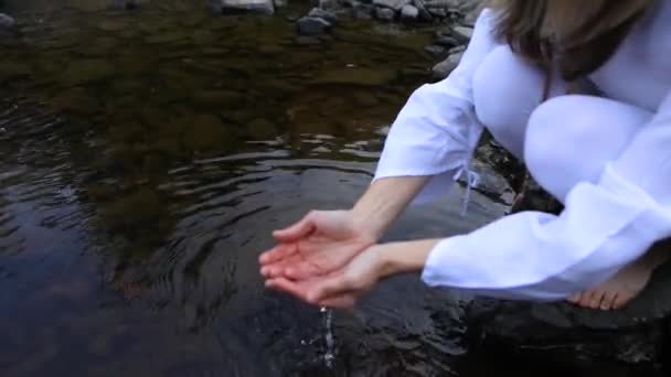 Женщина собирает воду — стоковое видео