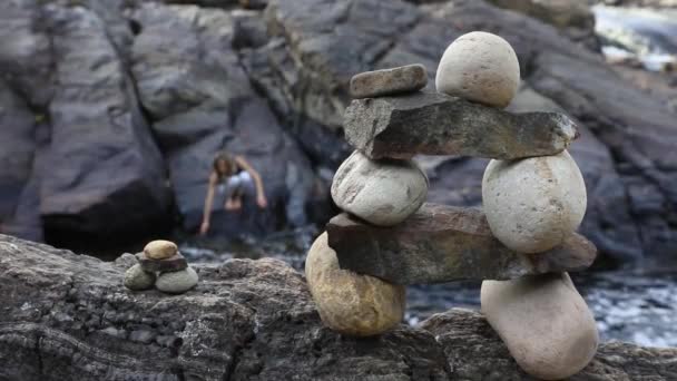 Balancing stone Inukshuks near the flowing river — Stock Video