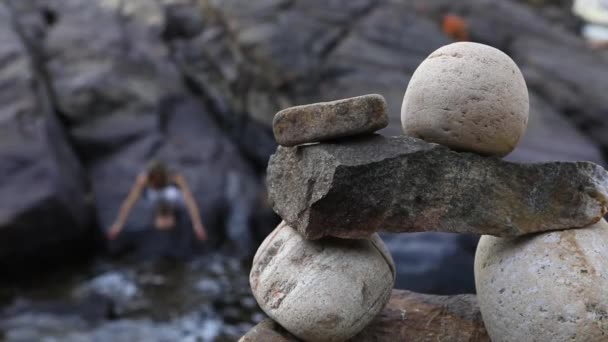 Balancing stone Inukshuks near the flowing river — Stock Video